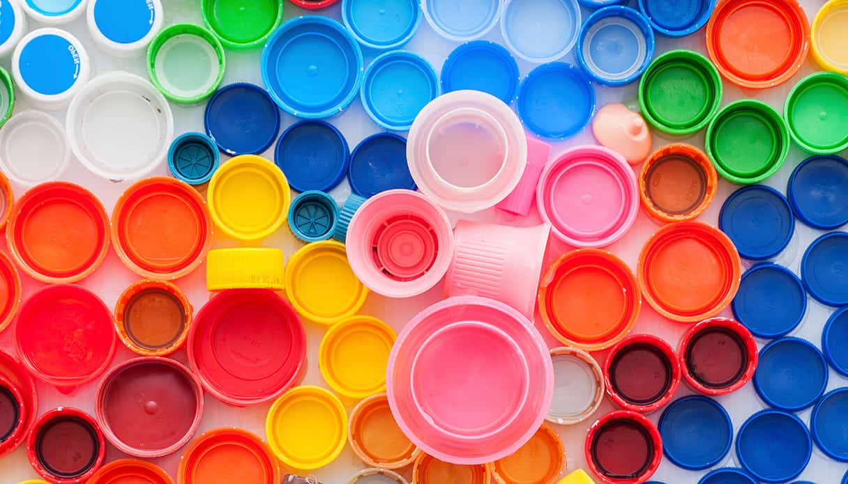 Un flatlay d'une collection de bouchons de bouteille en plastique de différentes couleurs.
