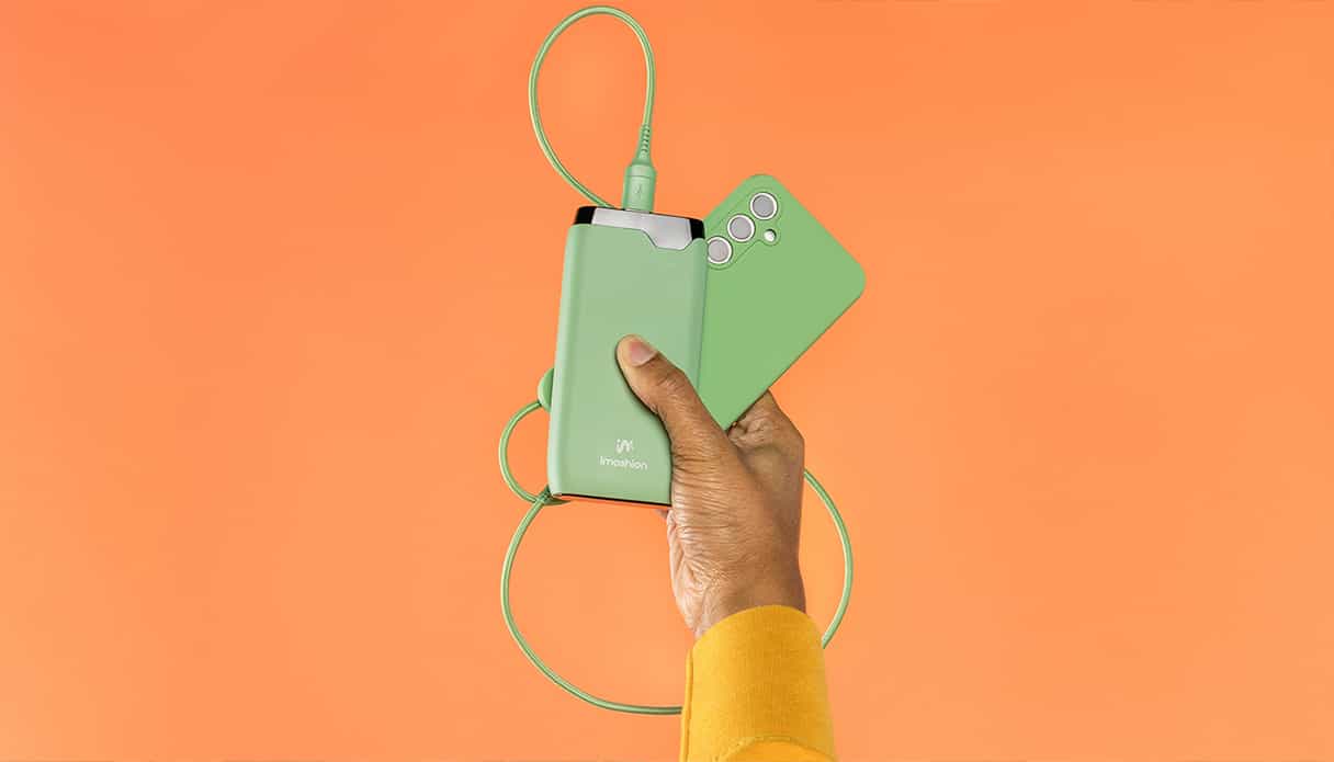 Un fond orange vif avec une batterie externe vert éclatant assortie à un téléphone.