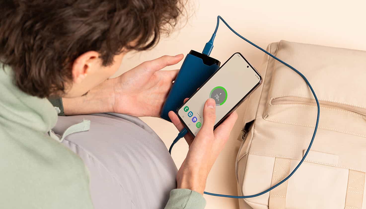 Le téléphone est connecté à une batterie externe et repose sur une valise à l'aéroport.