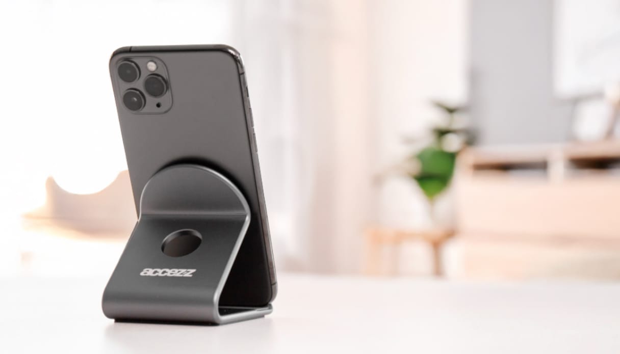 een apple iphone geplaatst in een zwarte telefoonstandaard