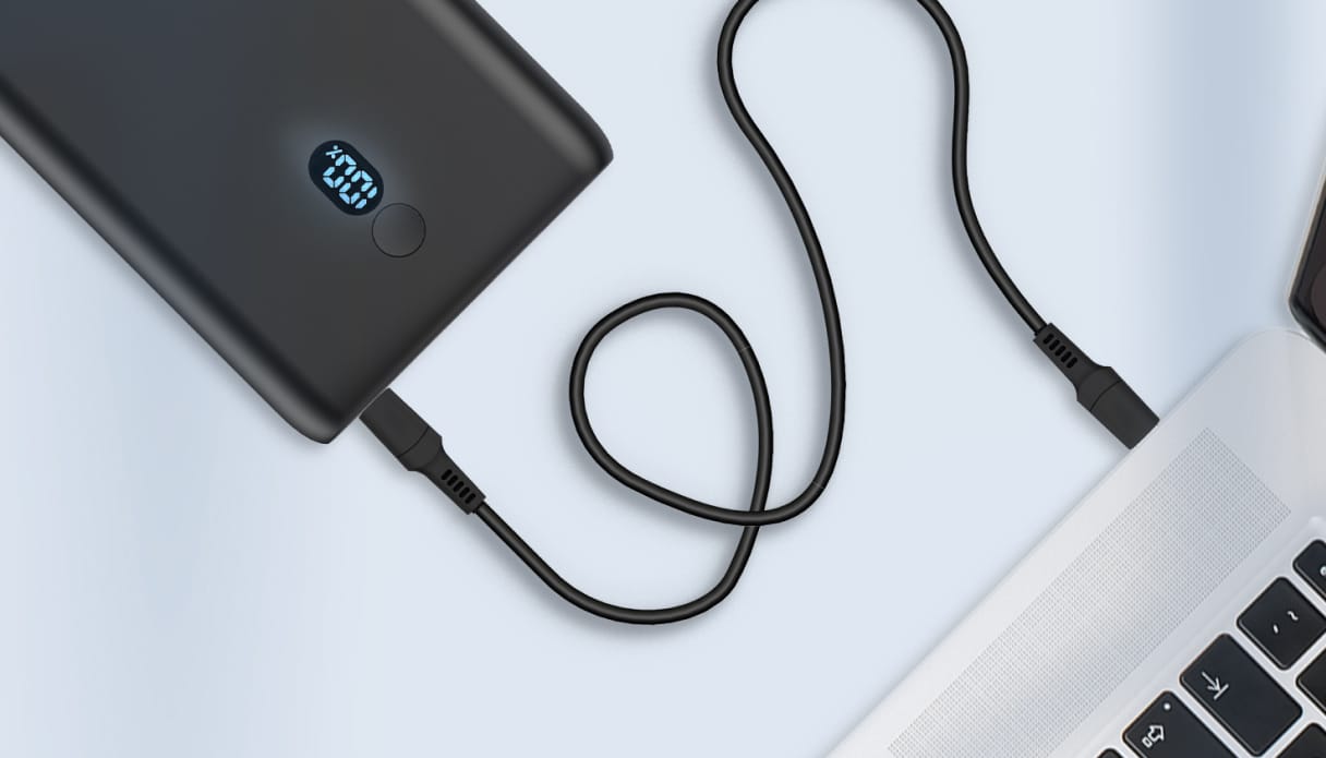 Une batterie externe imoshion connect&eacute;e &agrave; un MacBook.