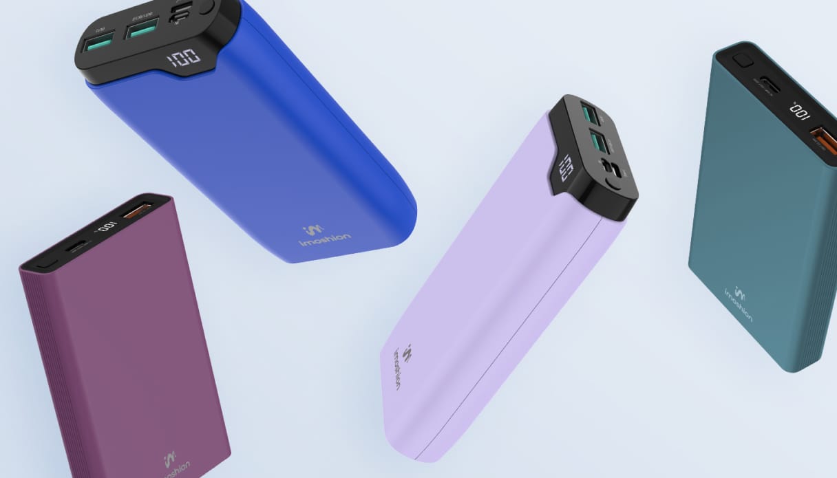 Quatre batteries externes color&eacute;es flottent sur un fond bleu clair.