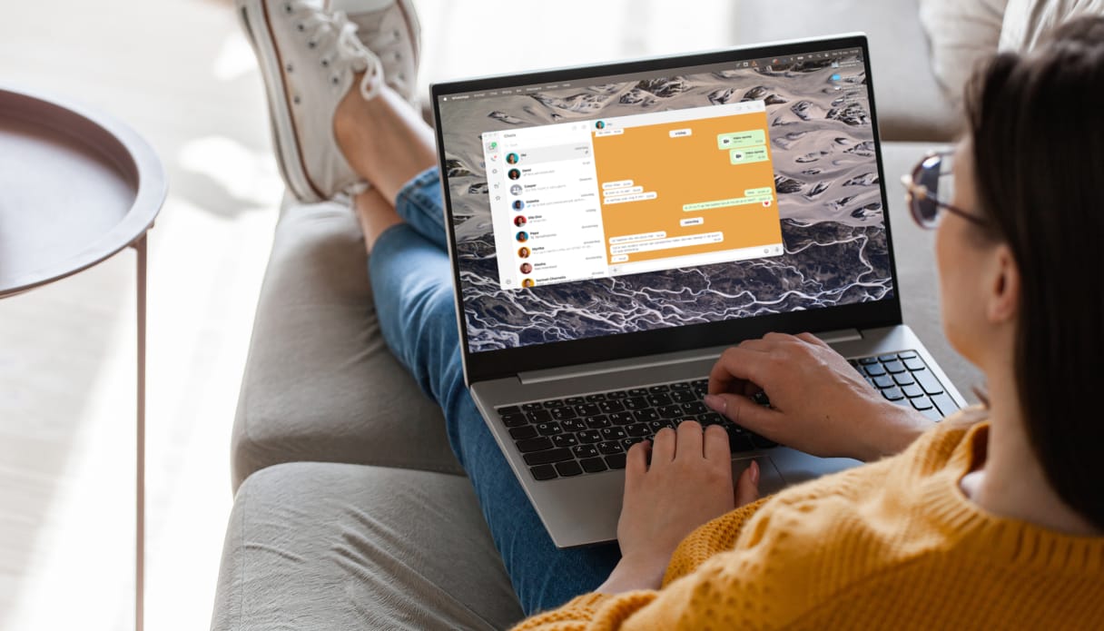 Une femme avec son ordinateur portable où WhatsApp est ouvert.