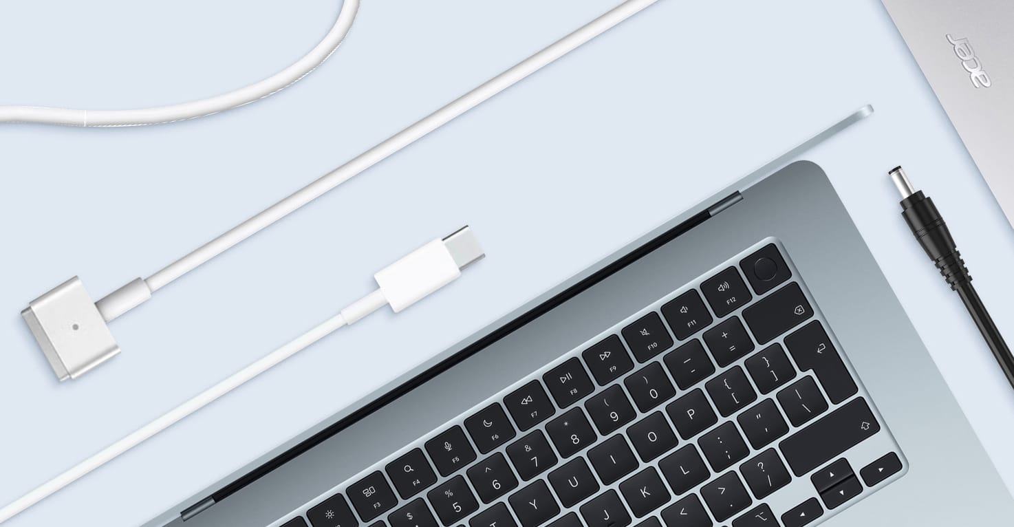 Un MacBook d'Apple et un ordinateur portable Acer entour&eacute;s de diff&eacute;rents types de chargeurs.