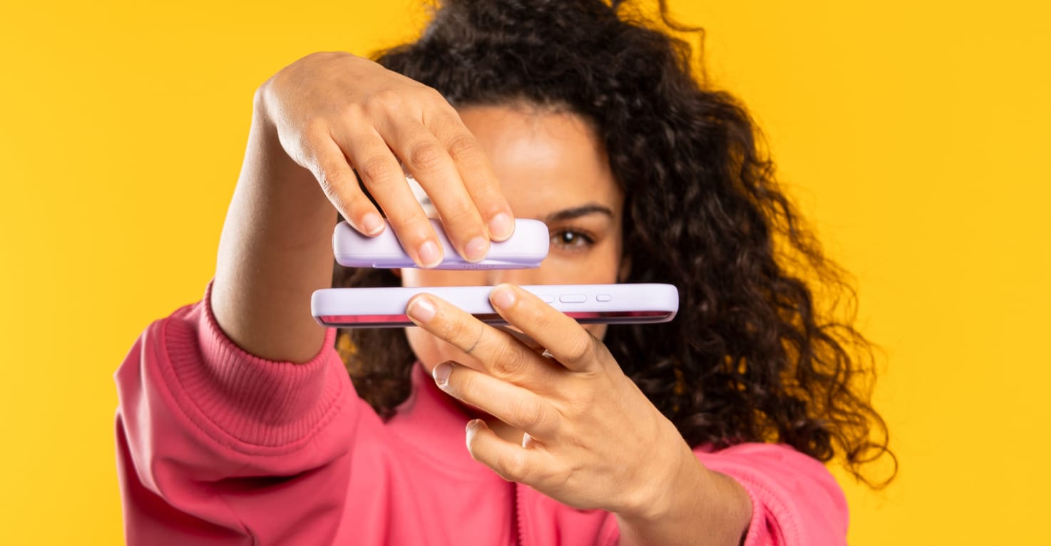 Une femme connecte une batterie externe à son téléphone à l'aide de MagSafe.