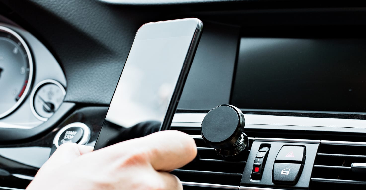 Une personne fixe un téléphone sur un support magnétique.