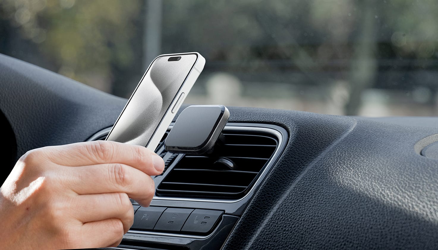Quelqu’un place un téléphone sur un support MagSafe pour voiture.