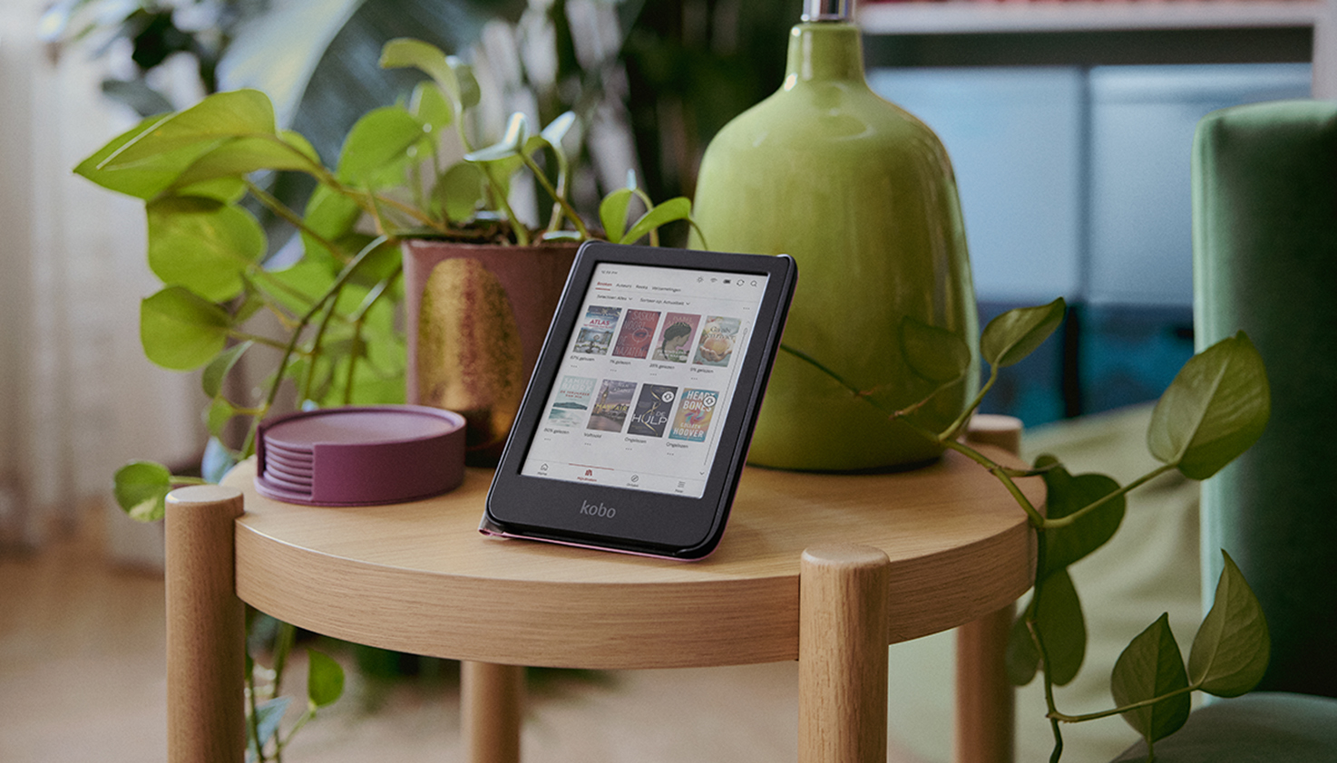 Le e-reader Kobo est posé sur une table avec des plantes.