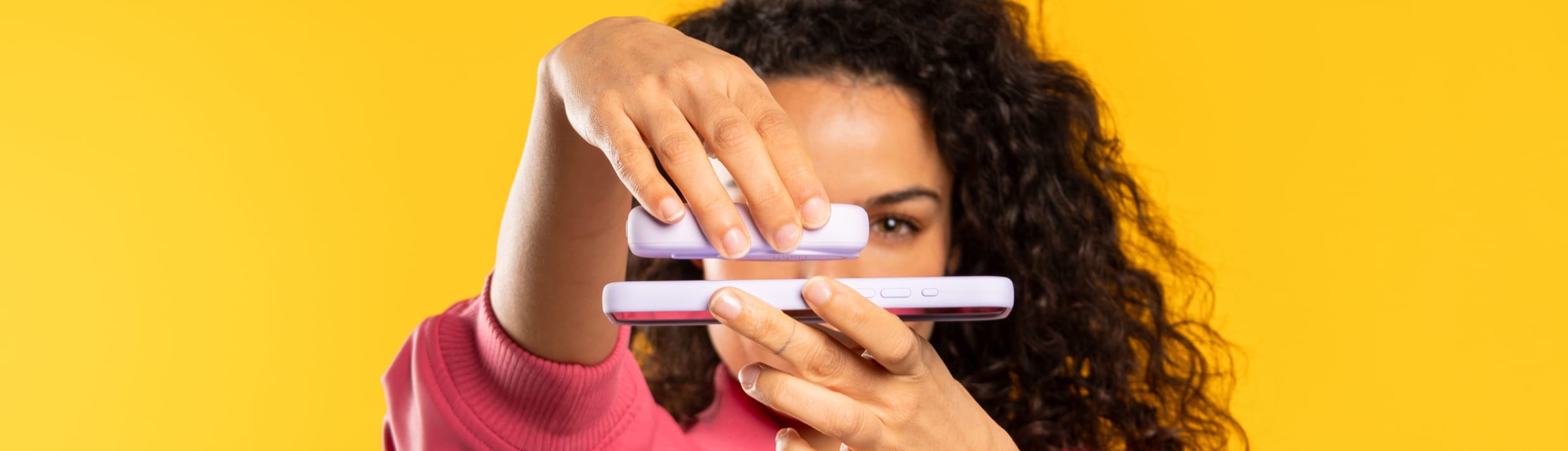Une femme connecte une batterie externe à son téléphone à l'aide de MagSafe.